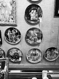 a black and white photo of a display of plates