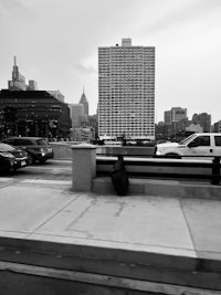 a black and white photo of cars parked on a sidewalk